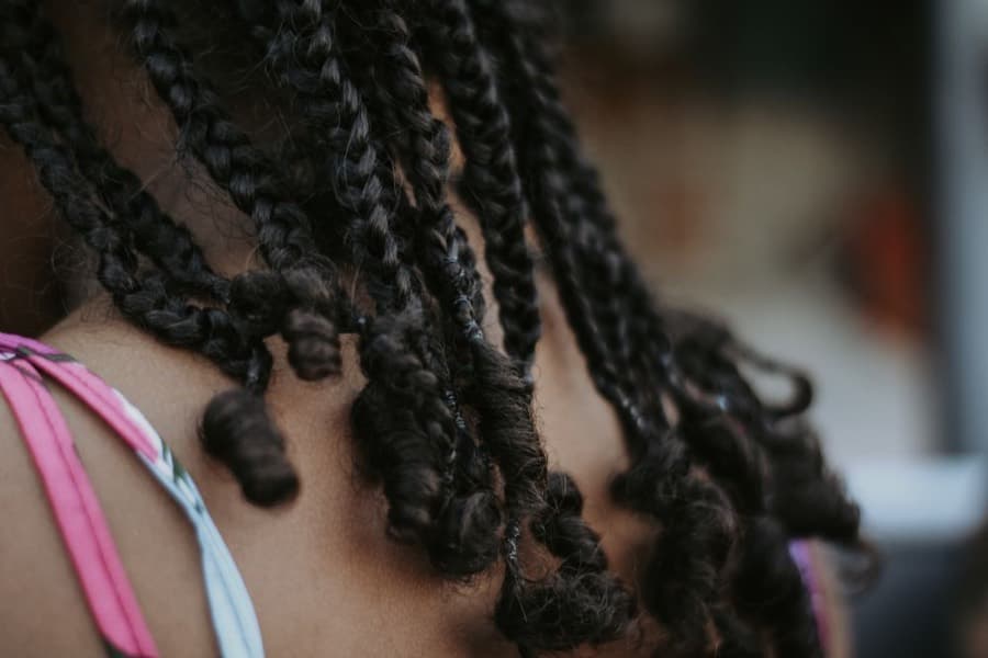 Hands finishing a set of braids