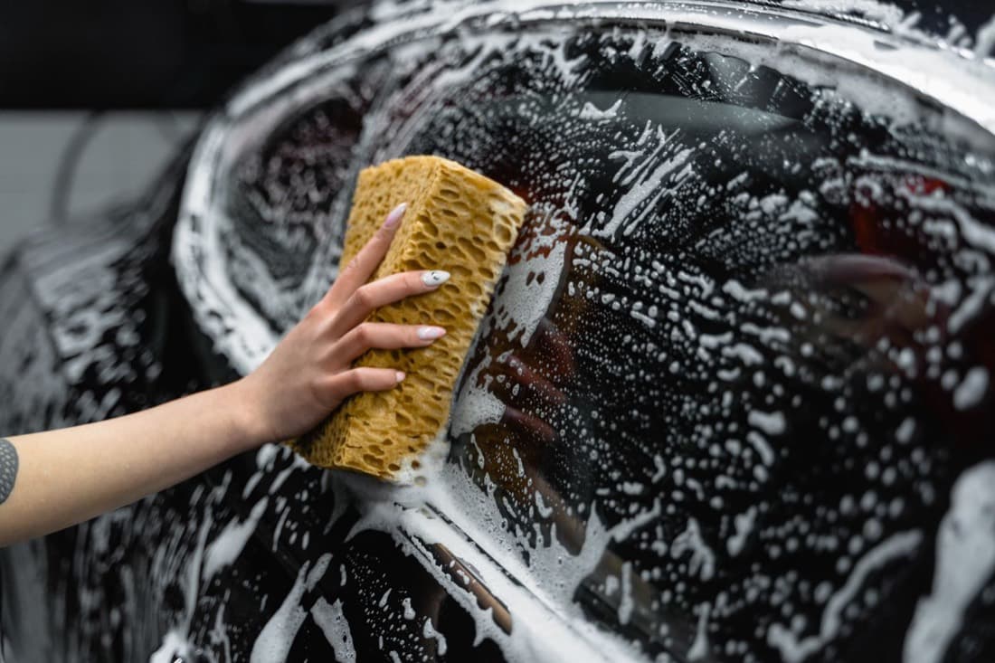 A sponge washing a foamy car