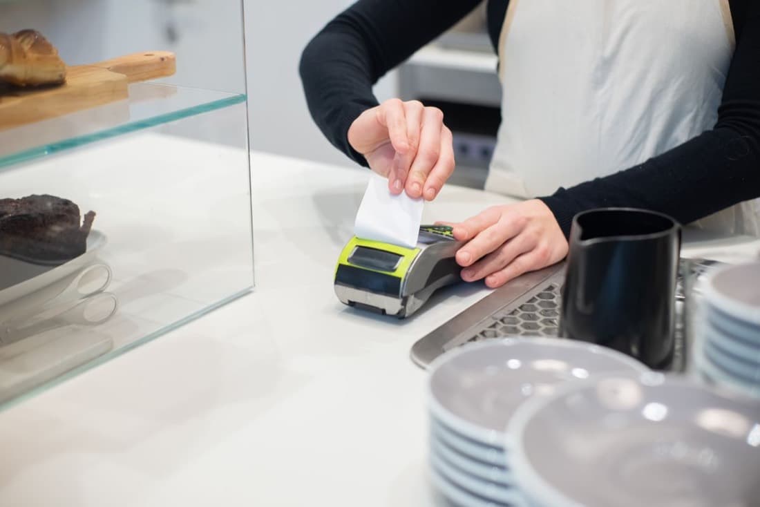 A card machine printing a receipt at a counter